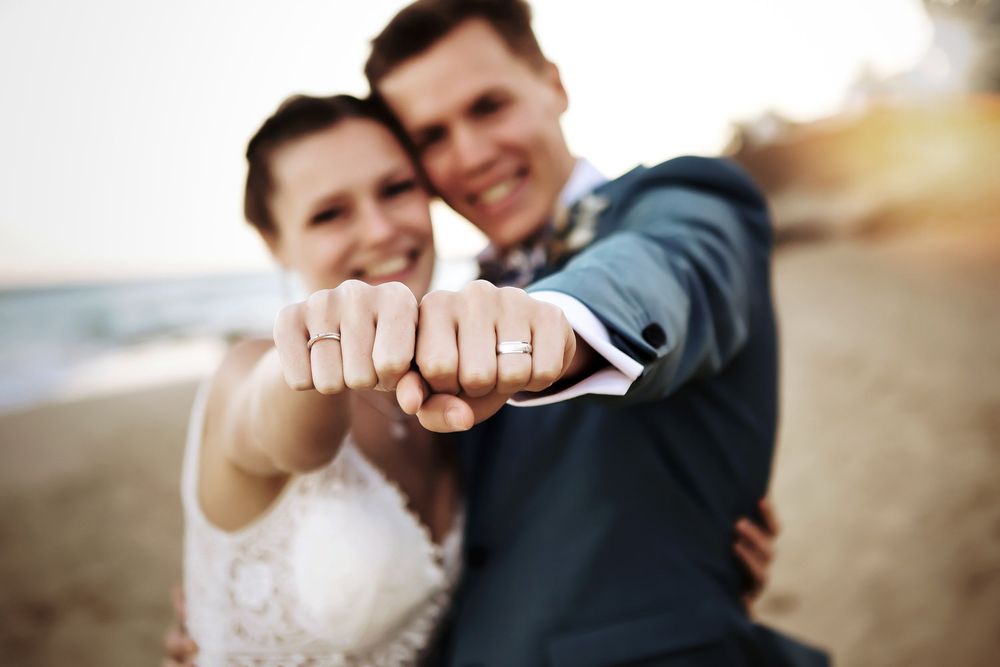 Close-up of a happy bride and groom showing their wedding rings on the beach in Jandia - Fuerteventura wedding photography