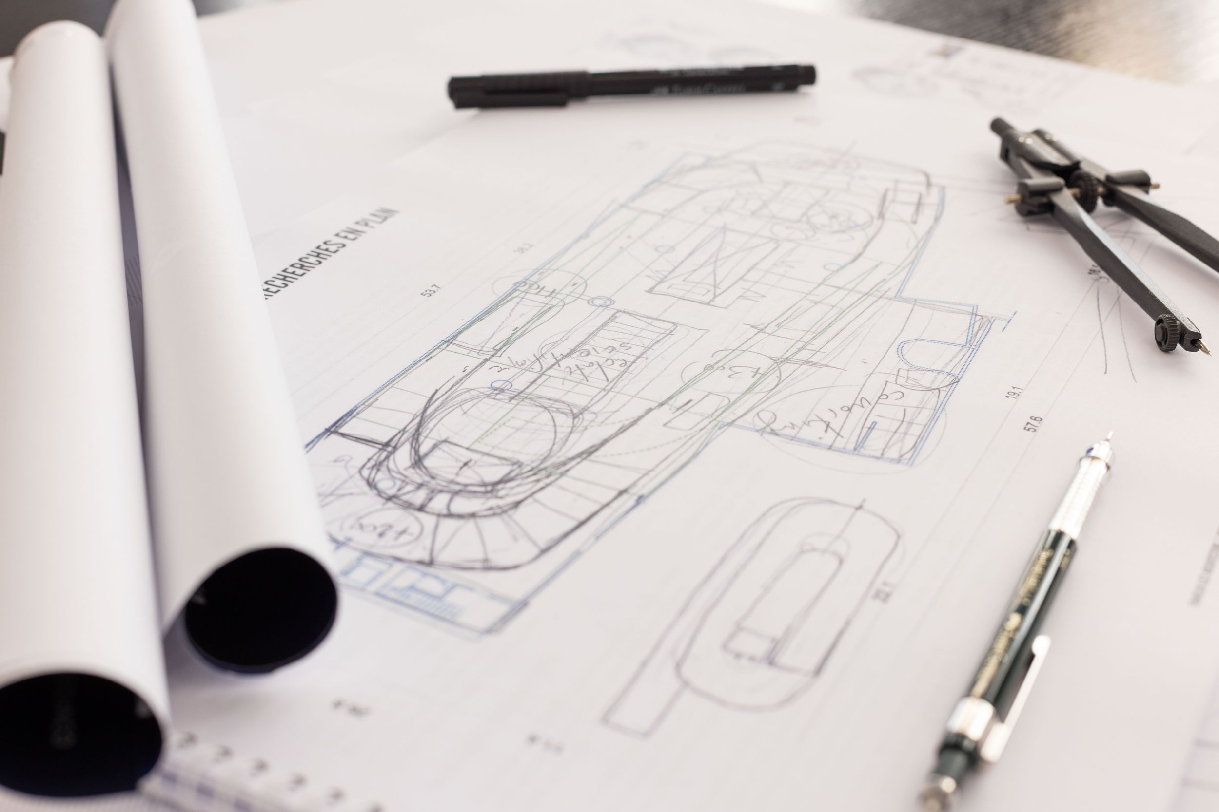 Plans d'architecte et compas sur table de travail, conception de projet immobilier haut de gamme.