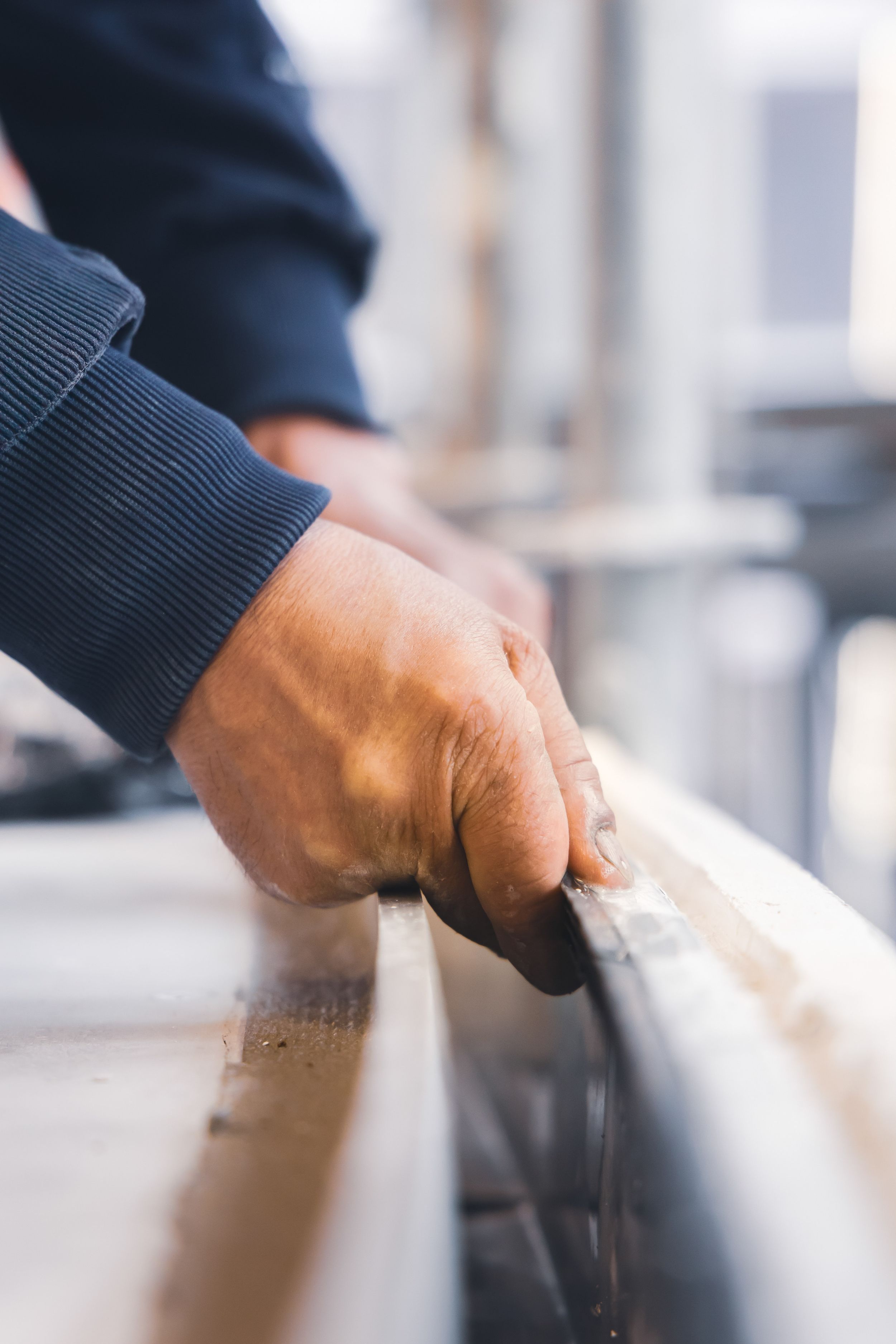 Reportage métier montrant un artisan au travail sur un plafond en bois suspendu.
