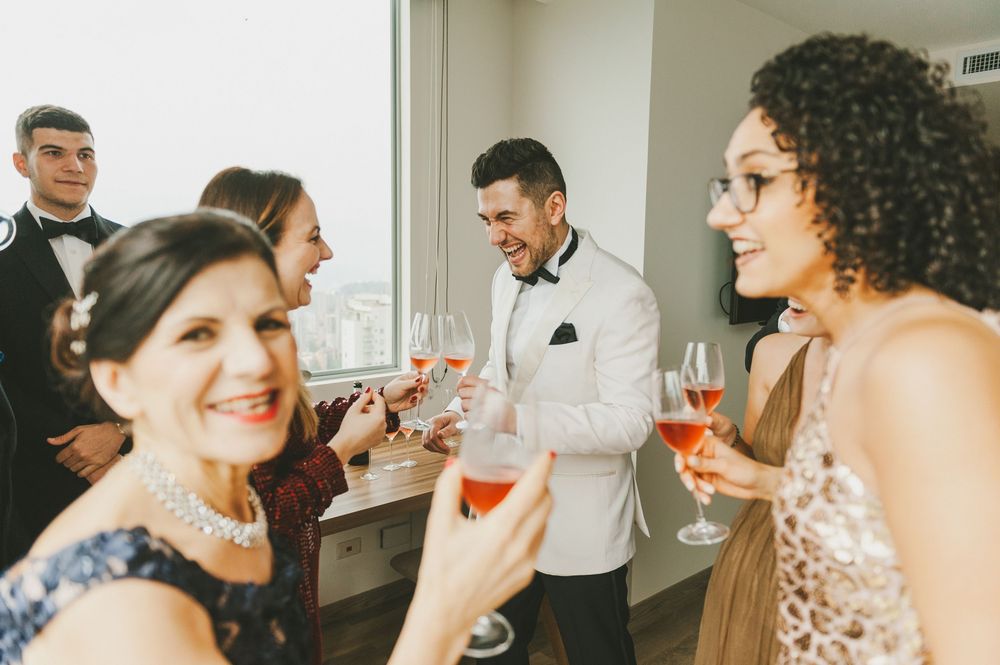 A group socializes and raises wine glasses in celebration during an elegant party.