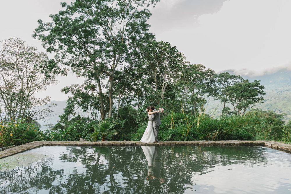 newlyweds kissing in front of Colombian trees
