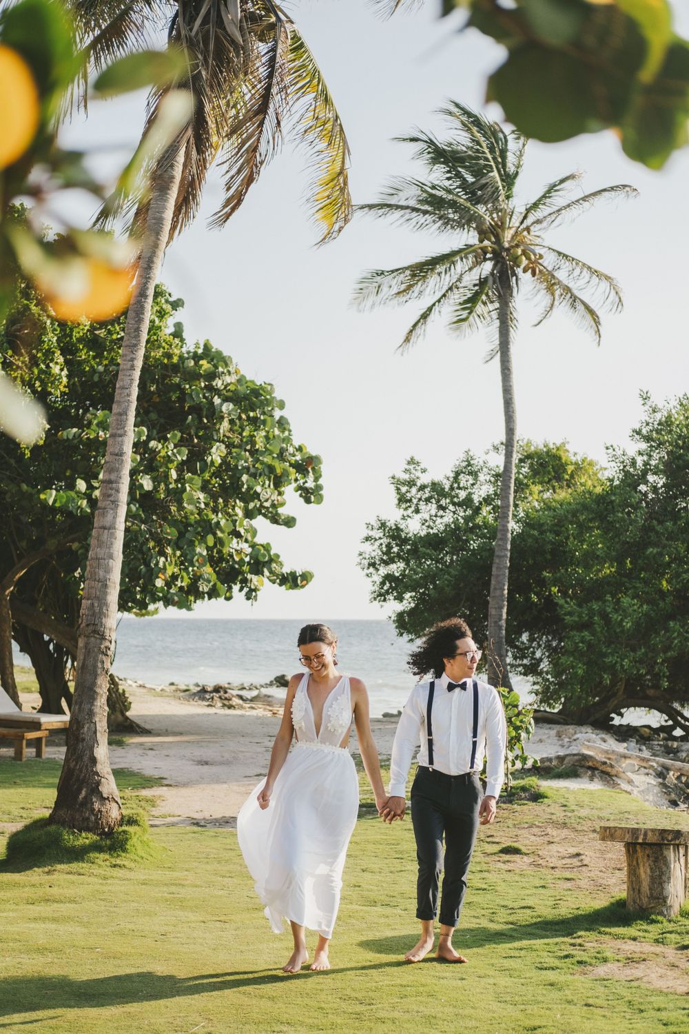 Newlyweds walking on a Colombian beach.
