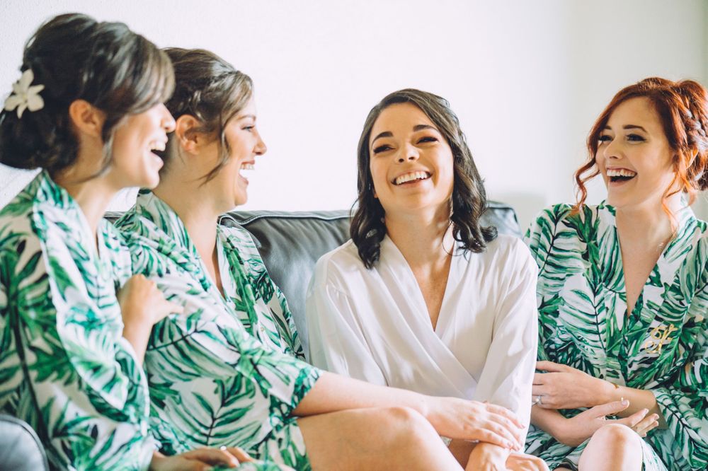 Group wearing matching tropical print robes sharing a joyful moment together.