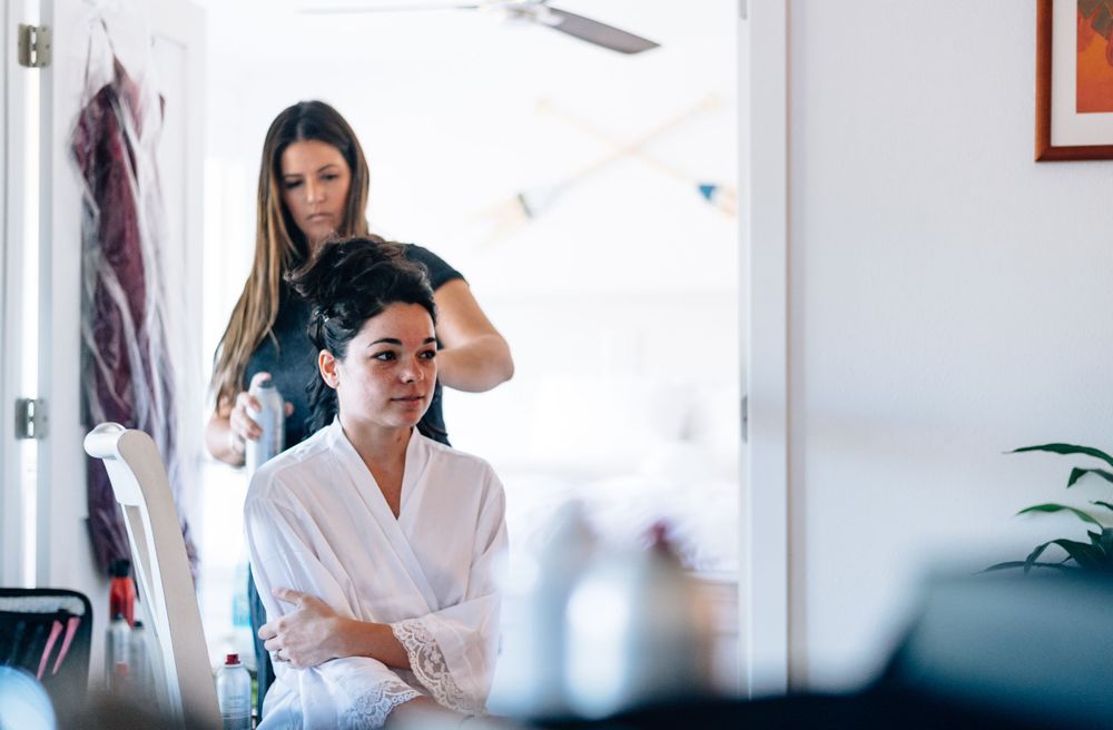 Wedding day preparation scene in bright white room with styling session.