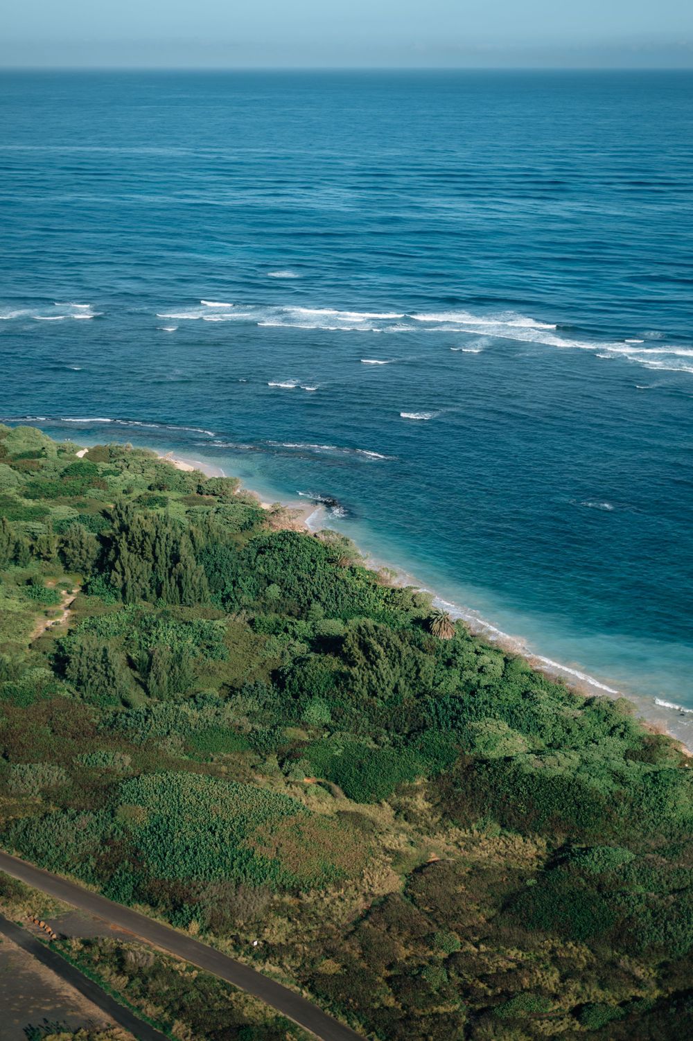 Scenic aerial photograph of turquoise ocean waters meeting tropical coastline.