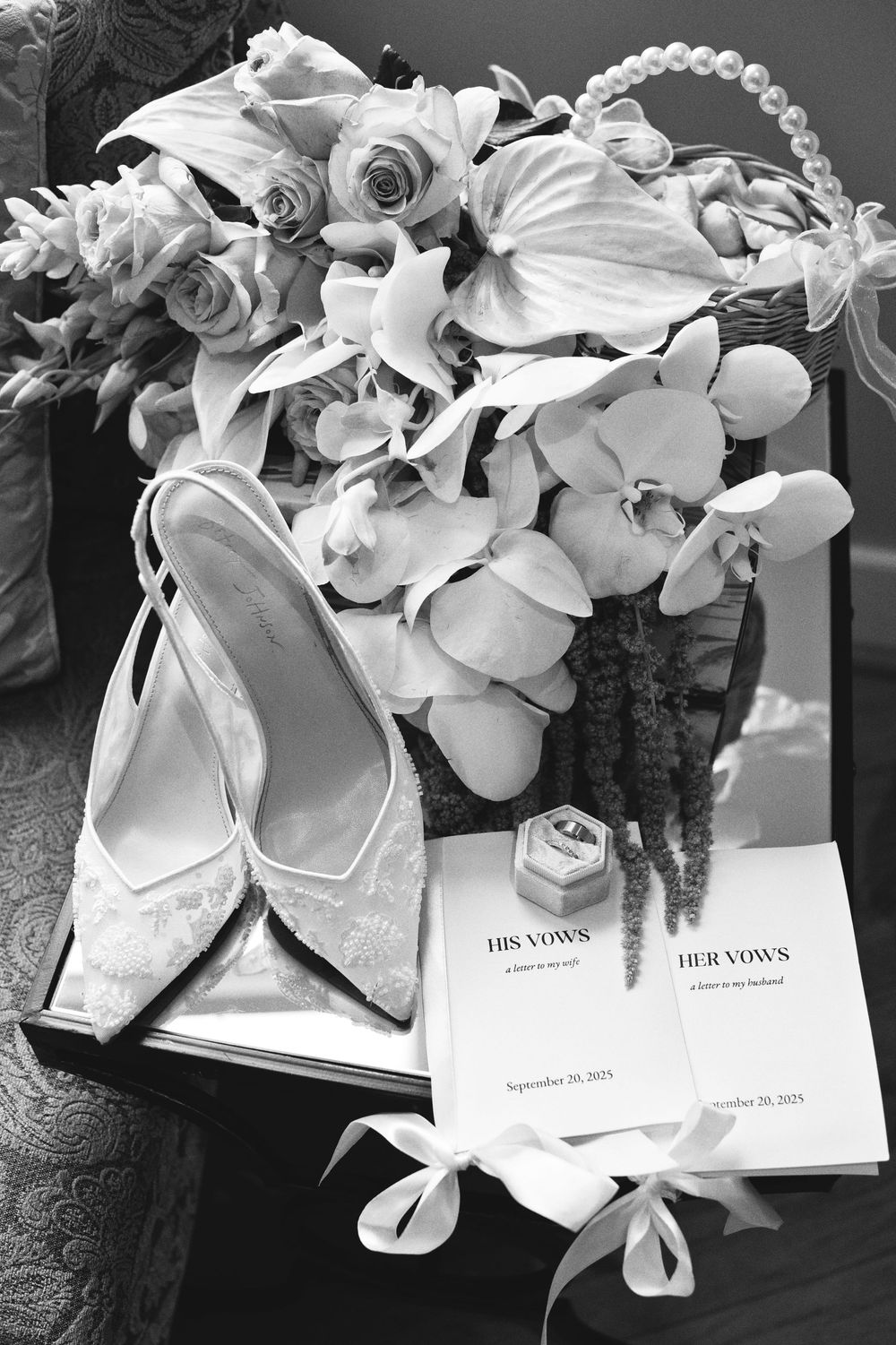 Black and white wedding detail photos showing orchid floral arrangements with invitation cards on display.