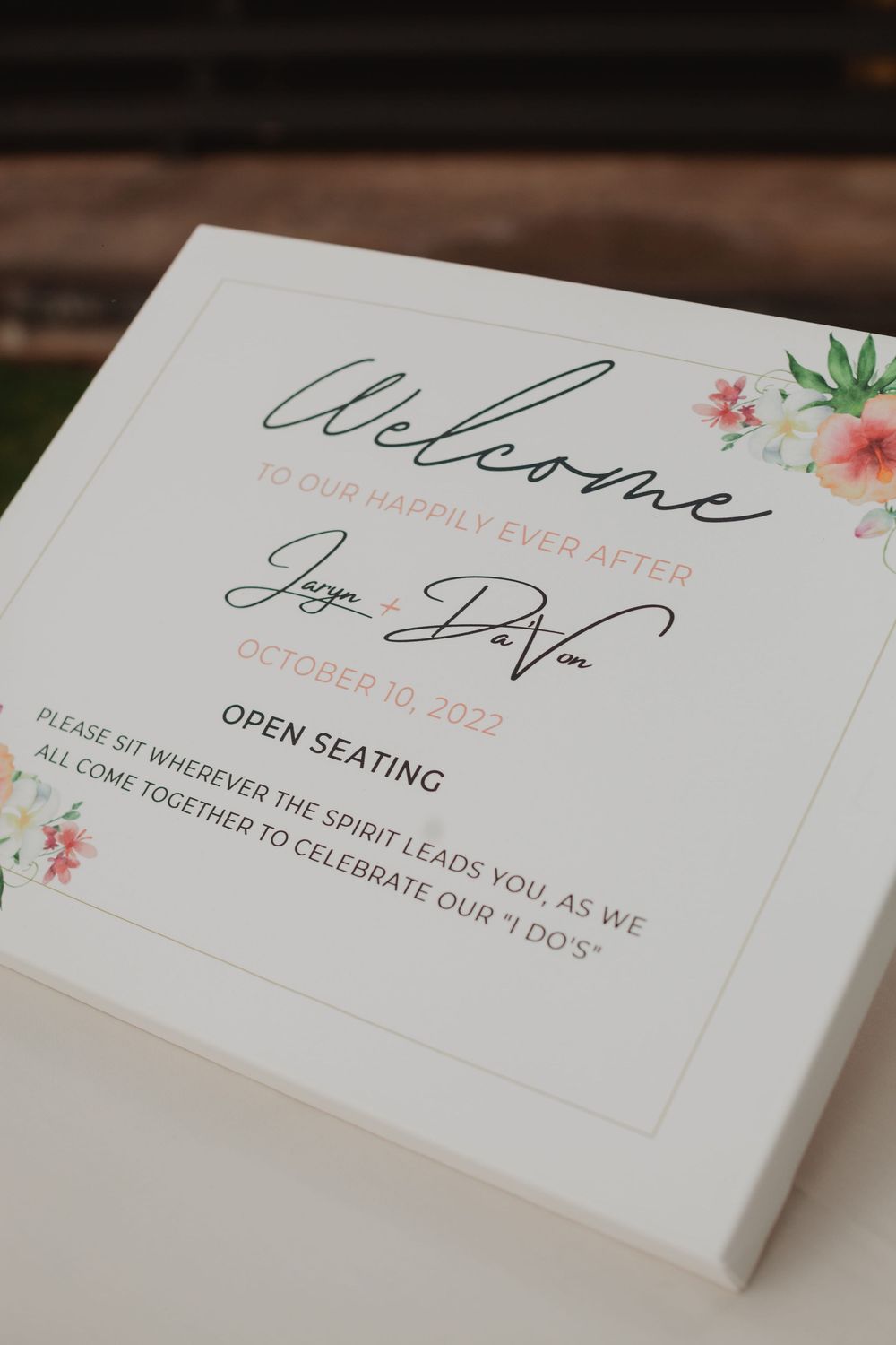 Wedding invitation cards with elegant cursive text and floral details laid out on a wooden surface.
