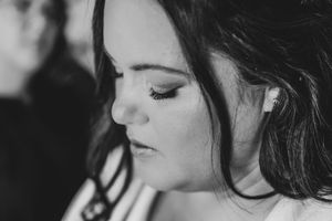 Black and white portrait of bride with elegant makeup and earring on wedding day.