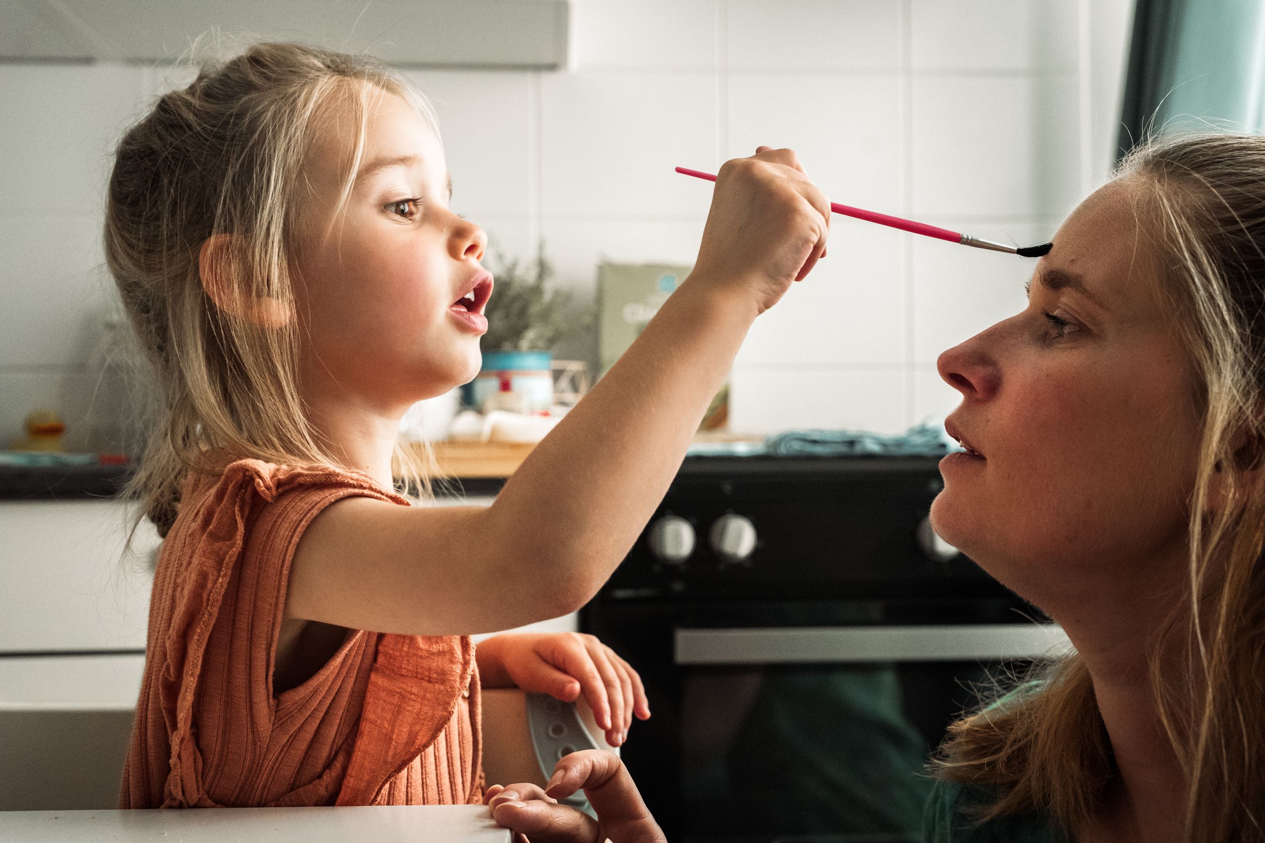 Two people sharing a red string between their mouths in artistic composition.