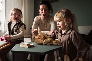 Family sharing meal together at dining table in moody lighting.
