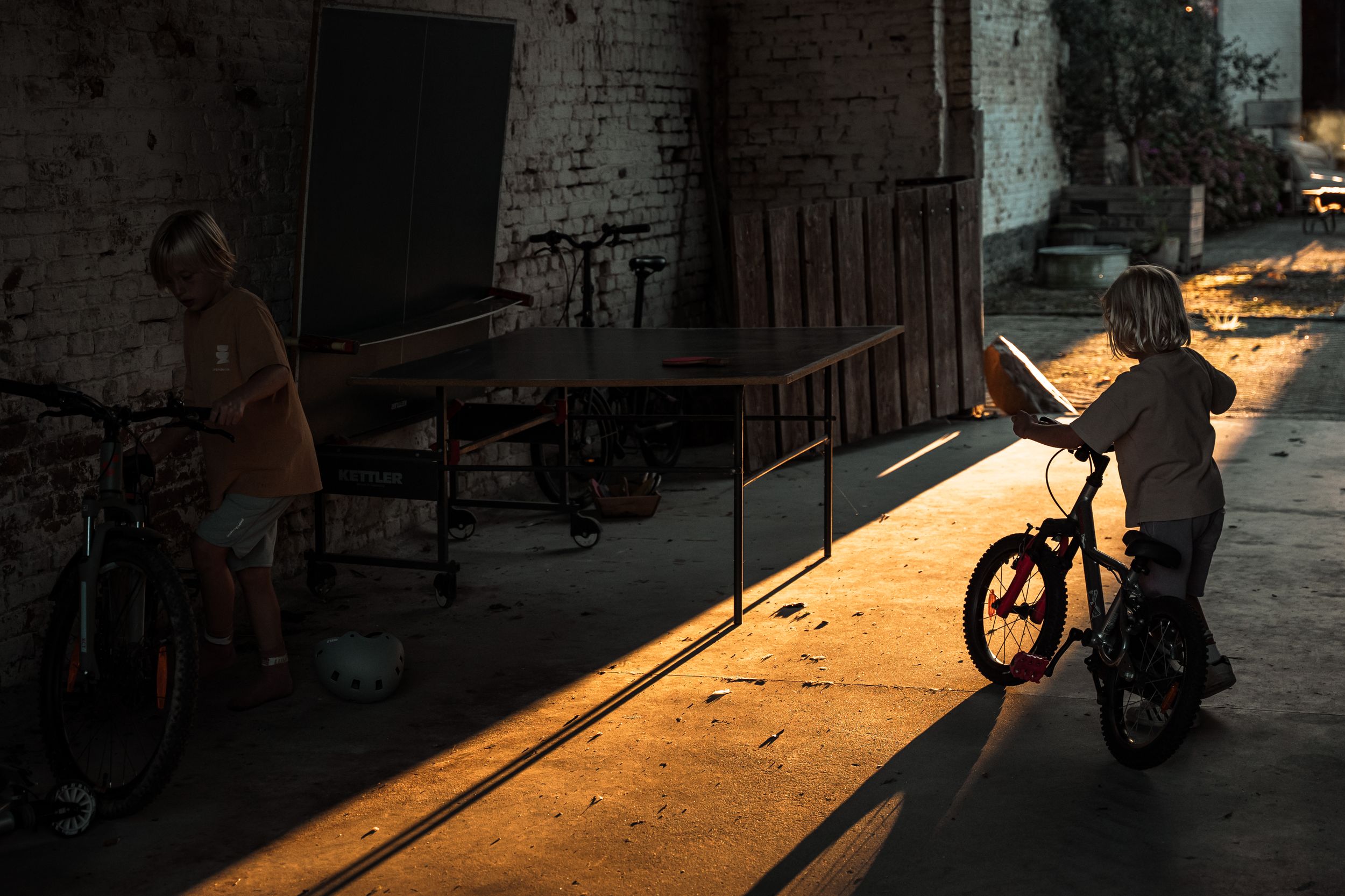 Dramatic shadows cast across a brick wall with sunlight streaming through.