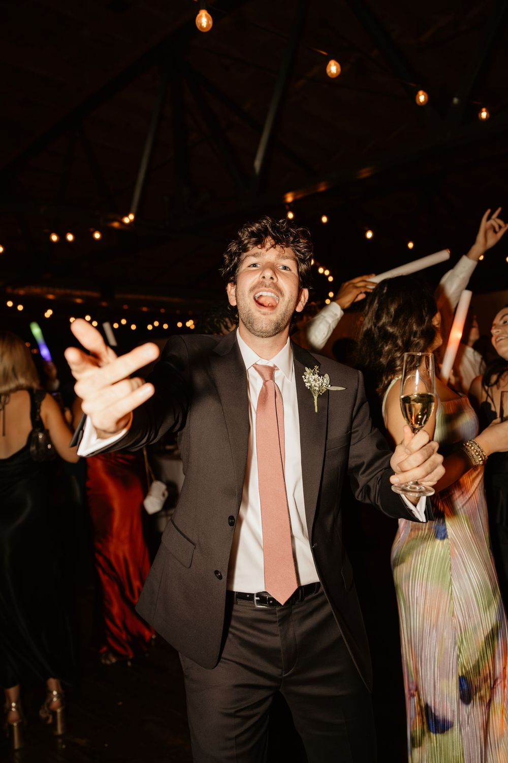 People dancing and celebrating at a dimly lit wedding reception with festive energy at Summerour Studio in Atlanta, Georgia