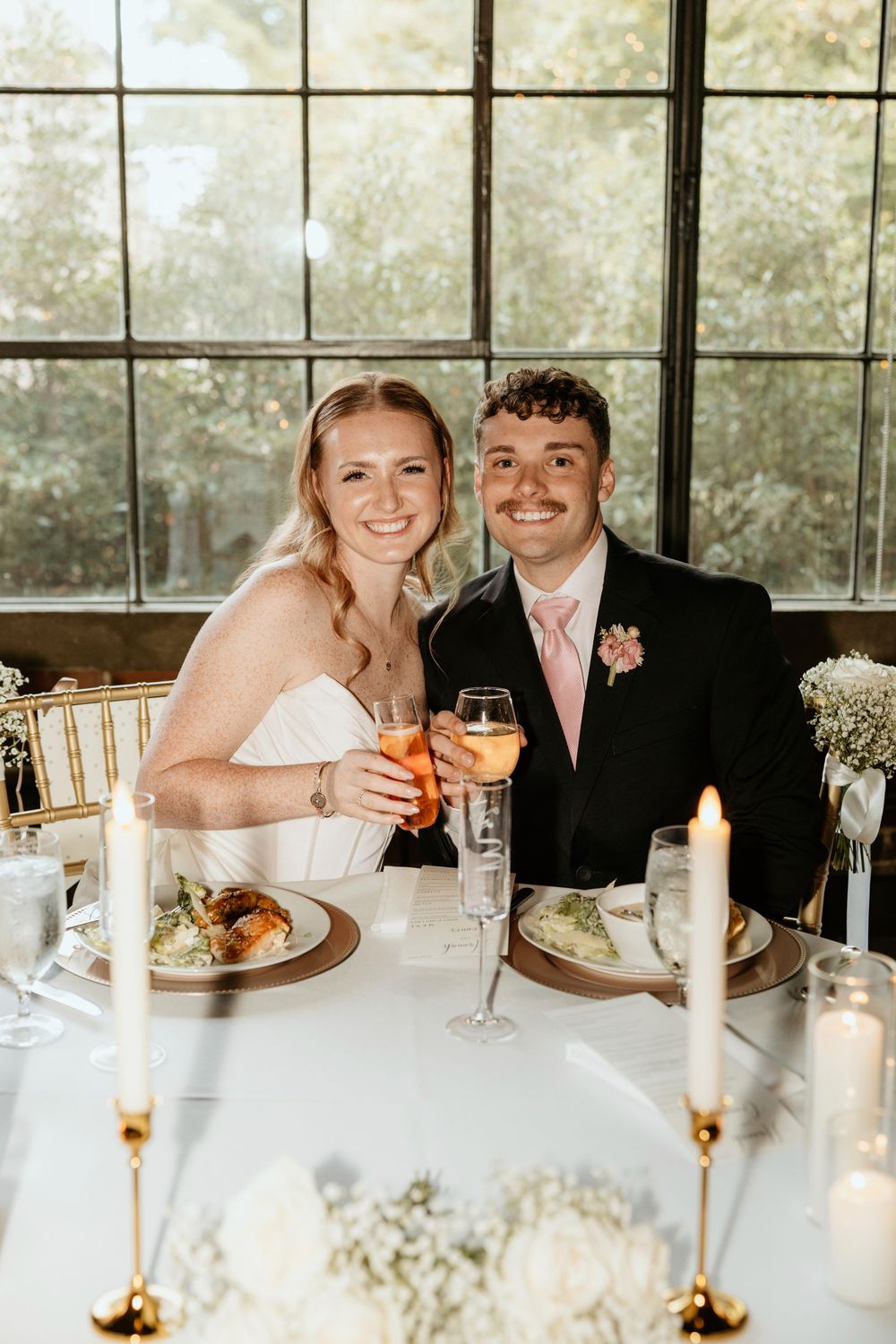 Newlywed couple toasts with champagne at elegant reception dinner table at Summerour Studio in Atlanta, Georgia