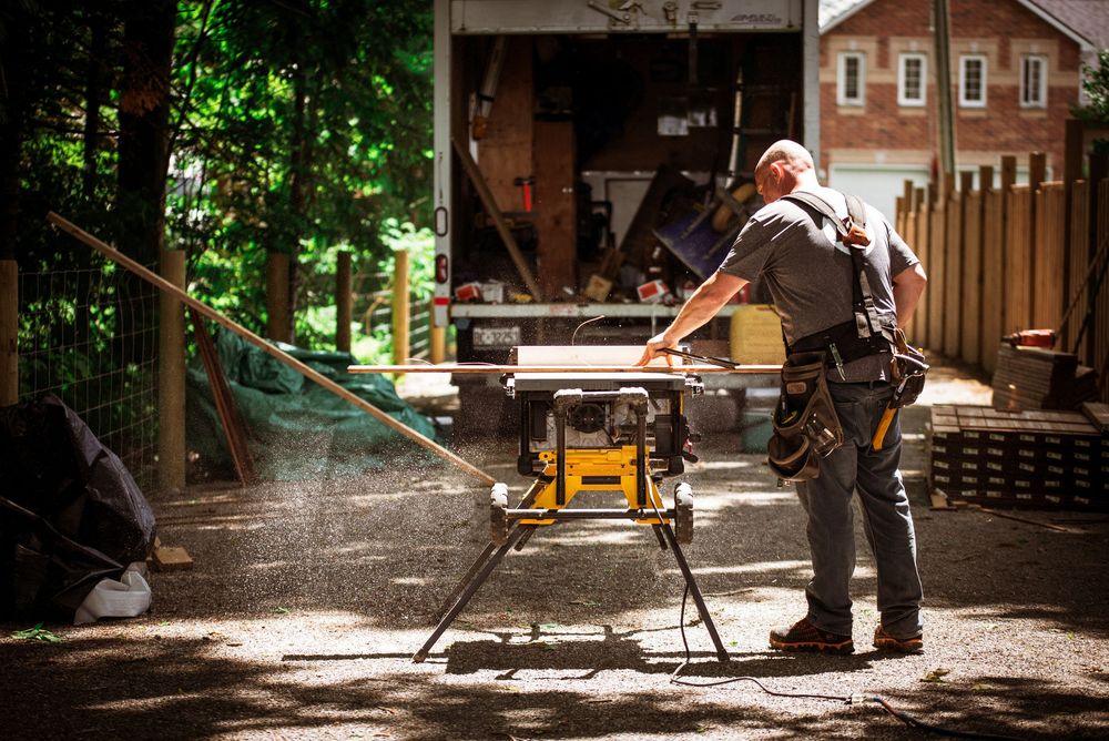 An employee for Align Decking cutting wood on a table saw during a branding photoshoot in Beaverton, Ontario.