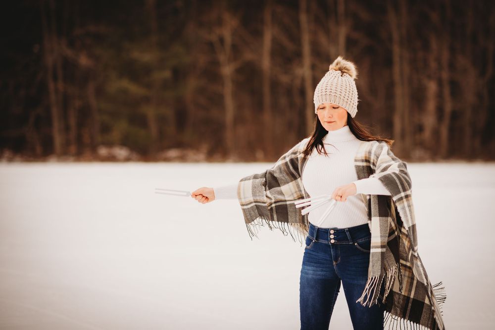 A lady posing with her tuning forks during an outdoor branding photoshoot in winter in Bolsover, Ontario.