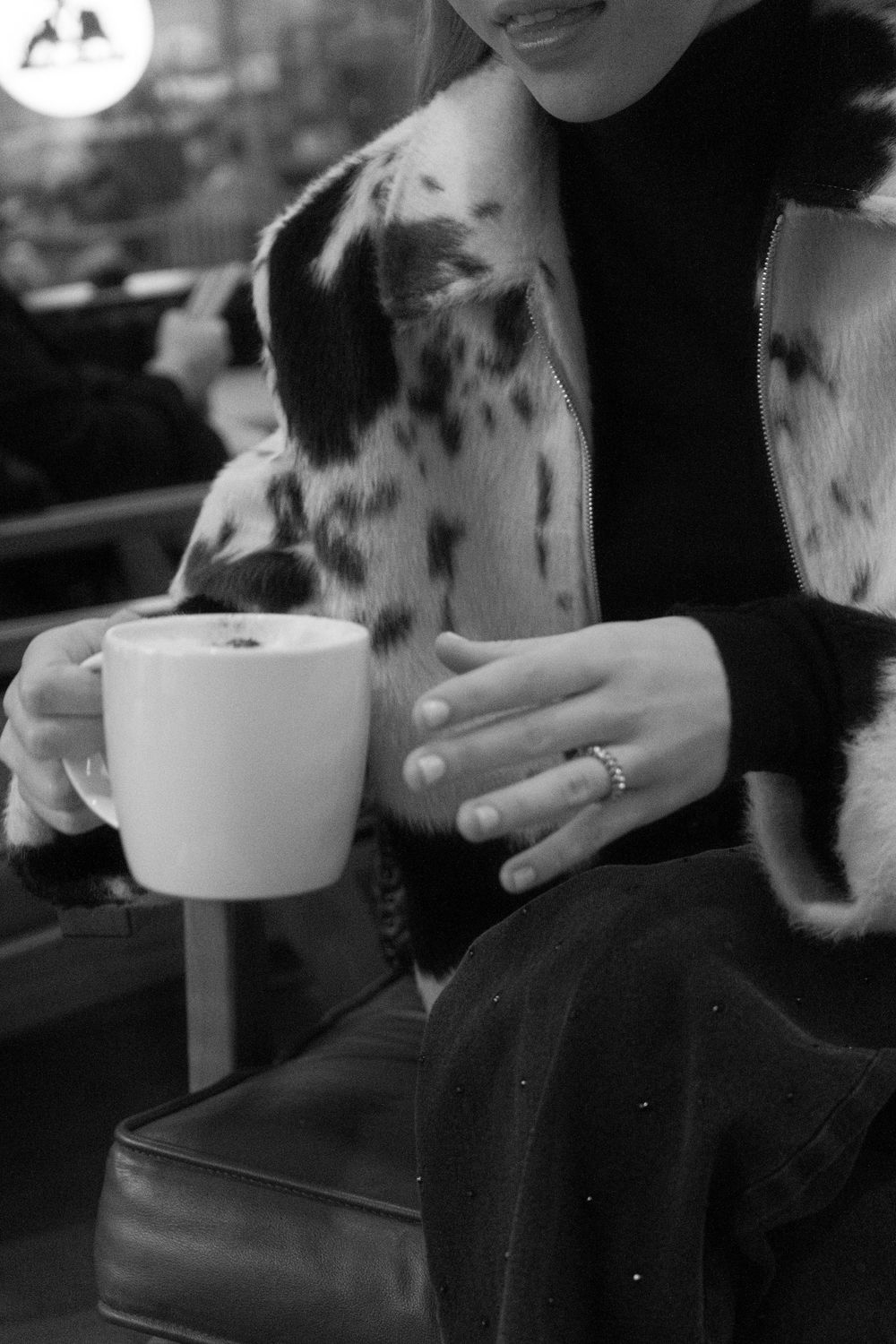 Black and white photo of spotted dog with coffee cup.