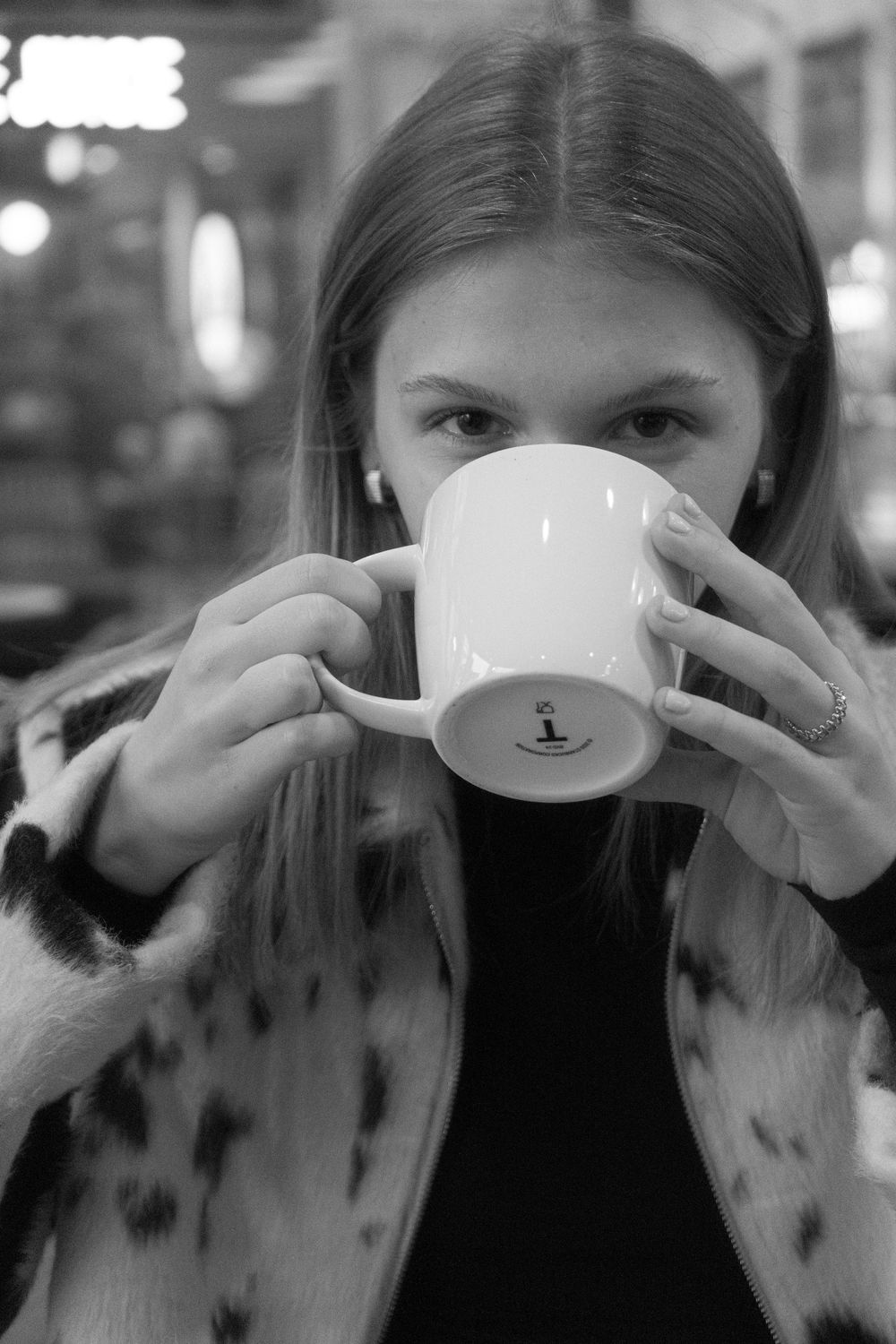 A sequence showing someone drinking from a white coffee cup in black and white photography.