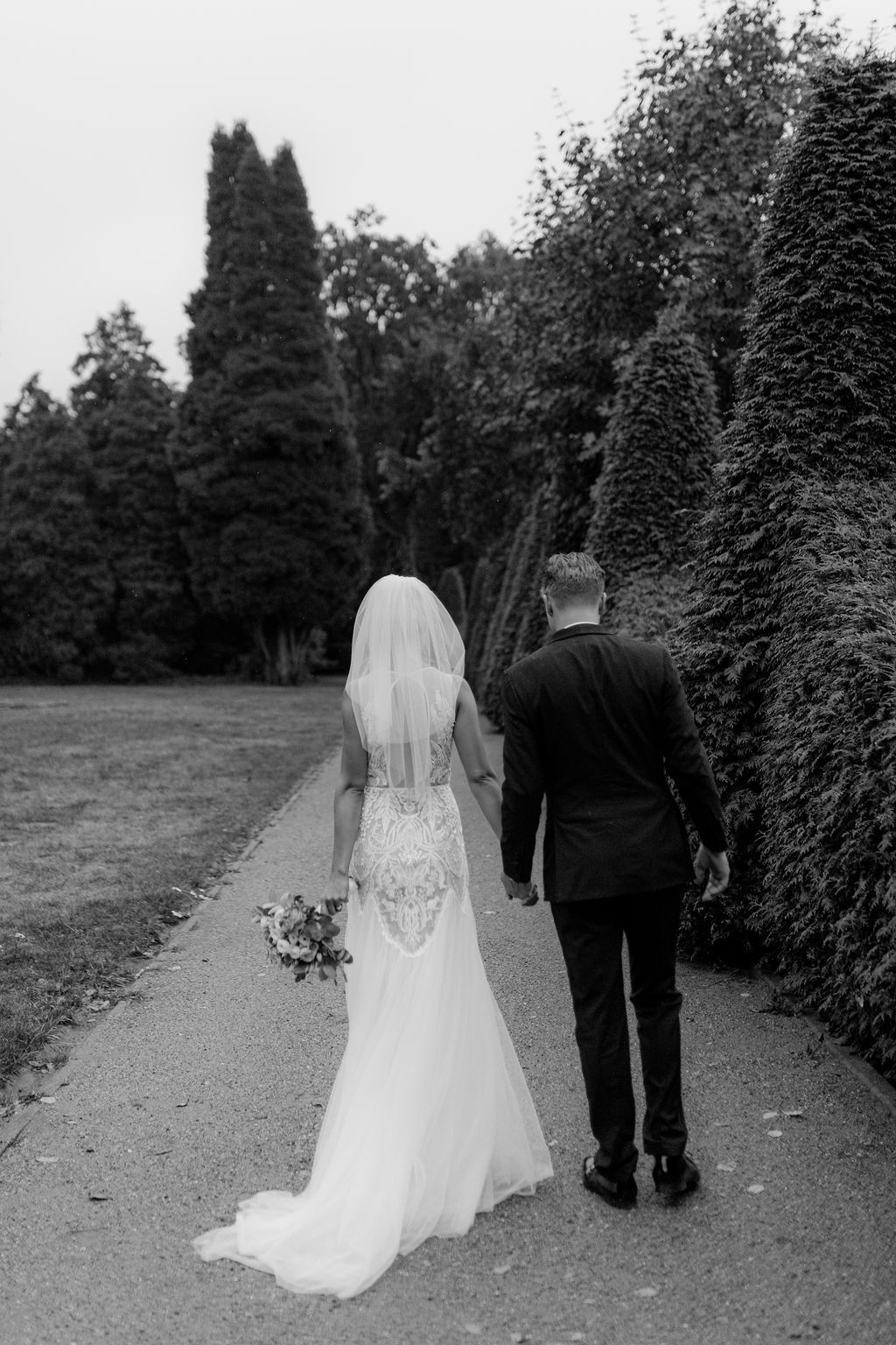 Wedding couple exits church as guests wave white handkerchiefs in celebration during traditional send-off ceremony.