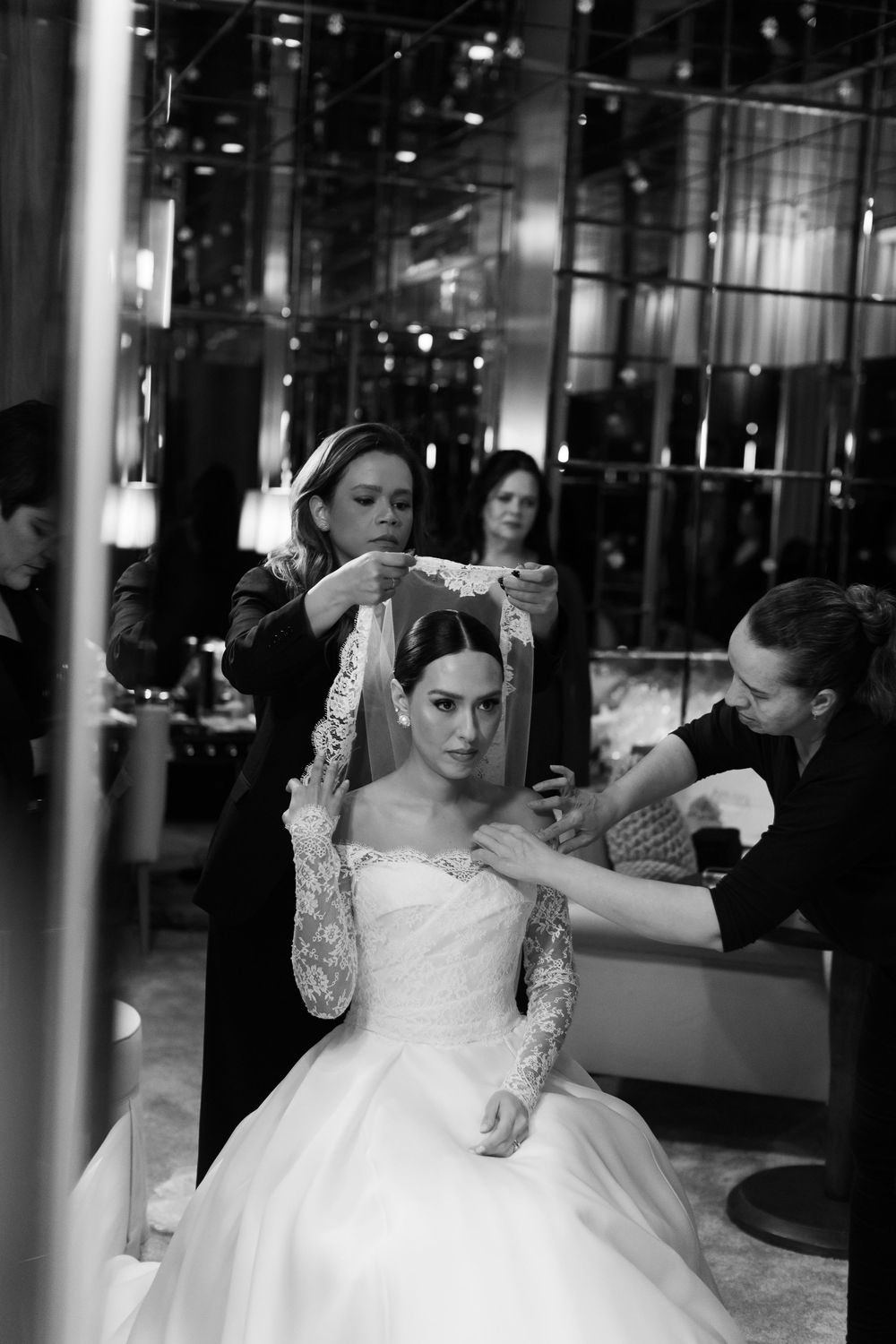 Behind-the-scenes moment of wedding preparations as stylists work on final touches.