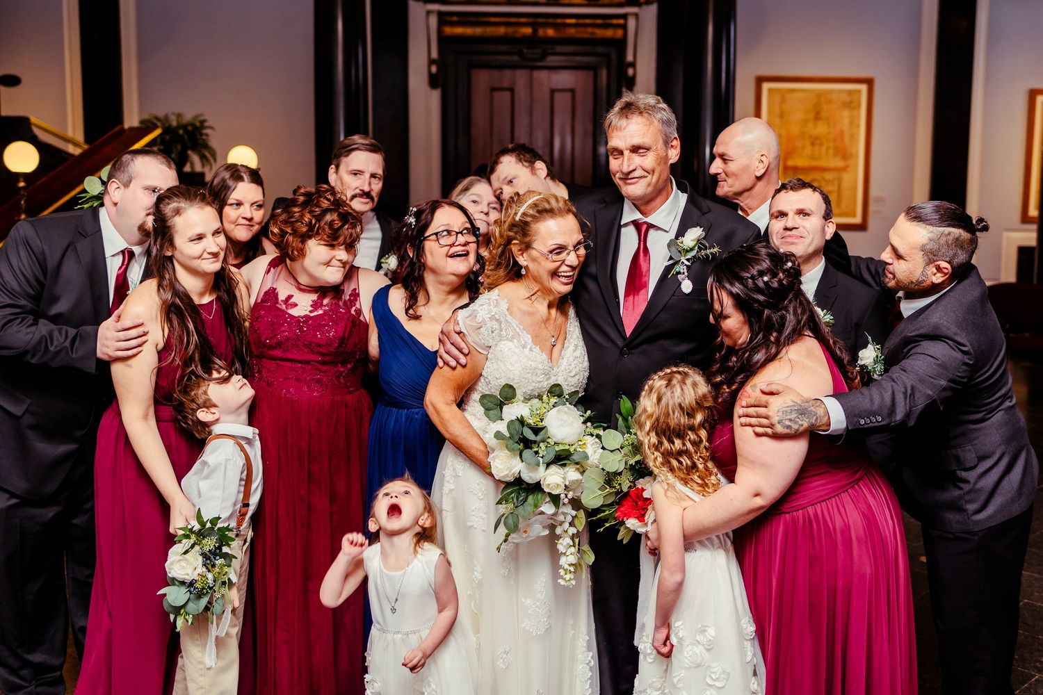 Wedding party poses together for fun group photo in formal attire.