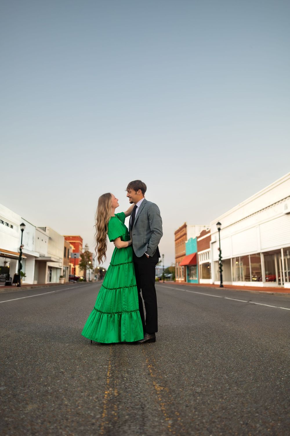Couple shares tender moments in empty small town street during photo session.