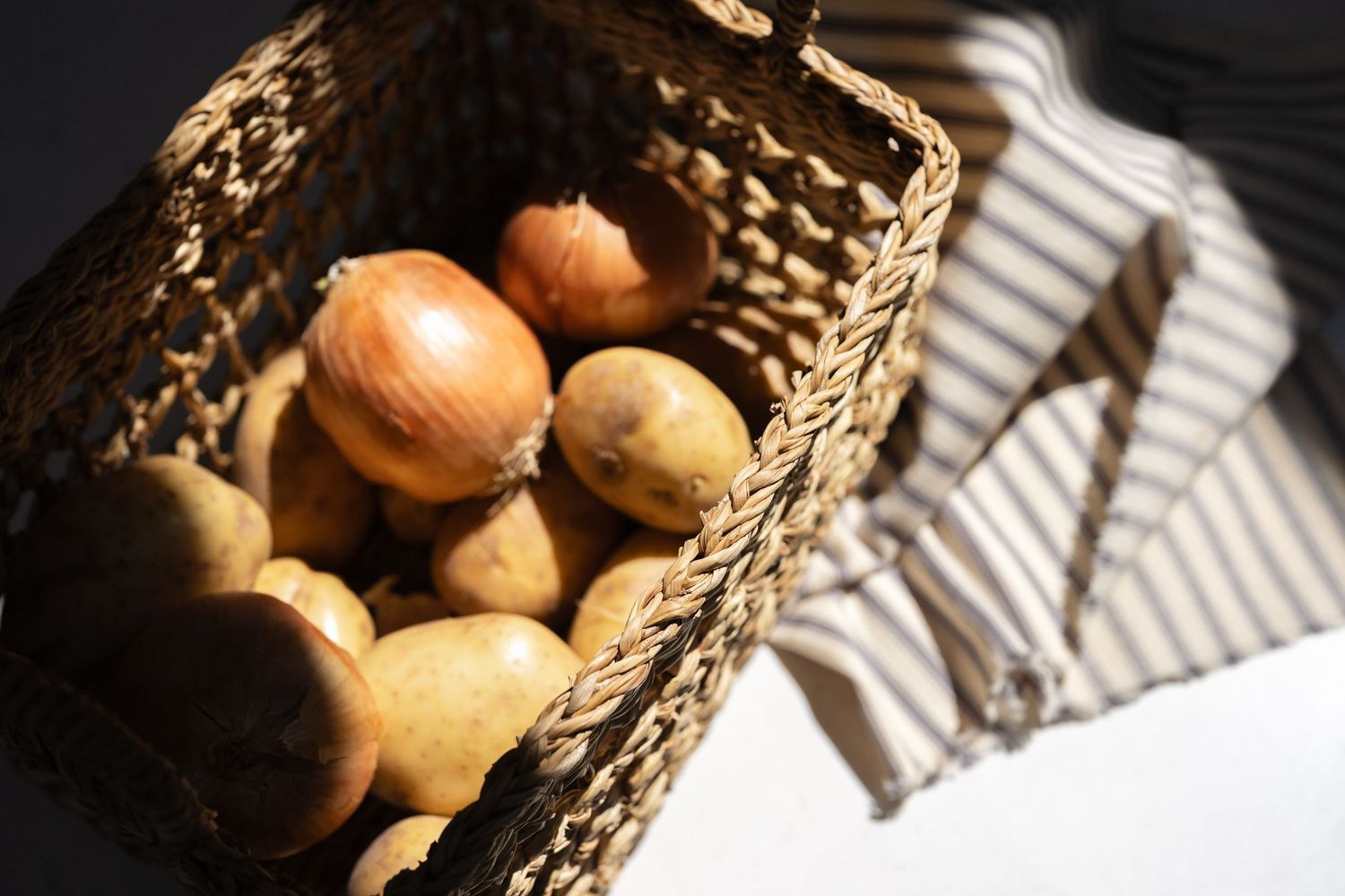 Rustic basket of potatoes photographed in natural window light for food brand photography
