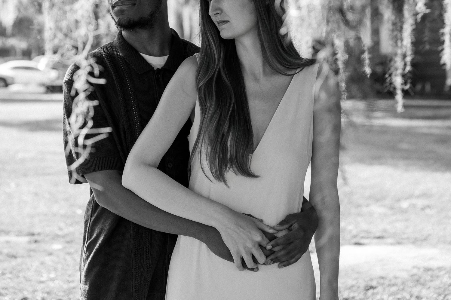 Black and white portraits of a couple embracing outdoors.