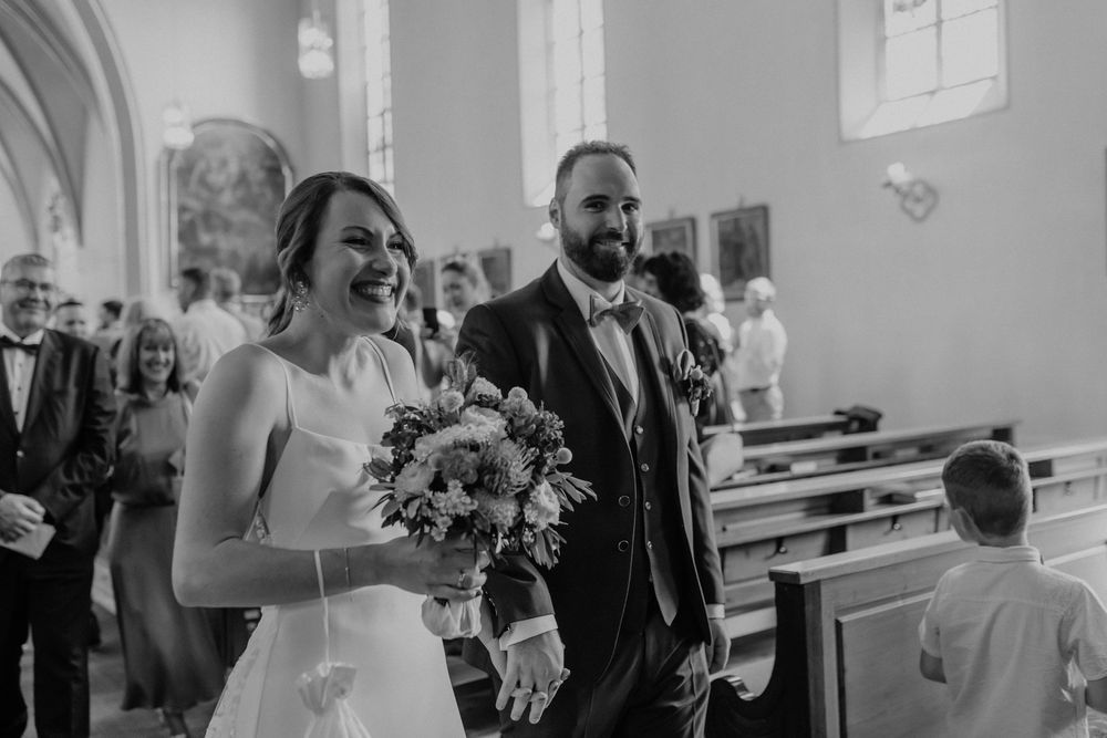 Wedding ceremony taking place in a bright church sanctuary with traditional decor.