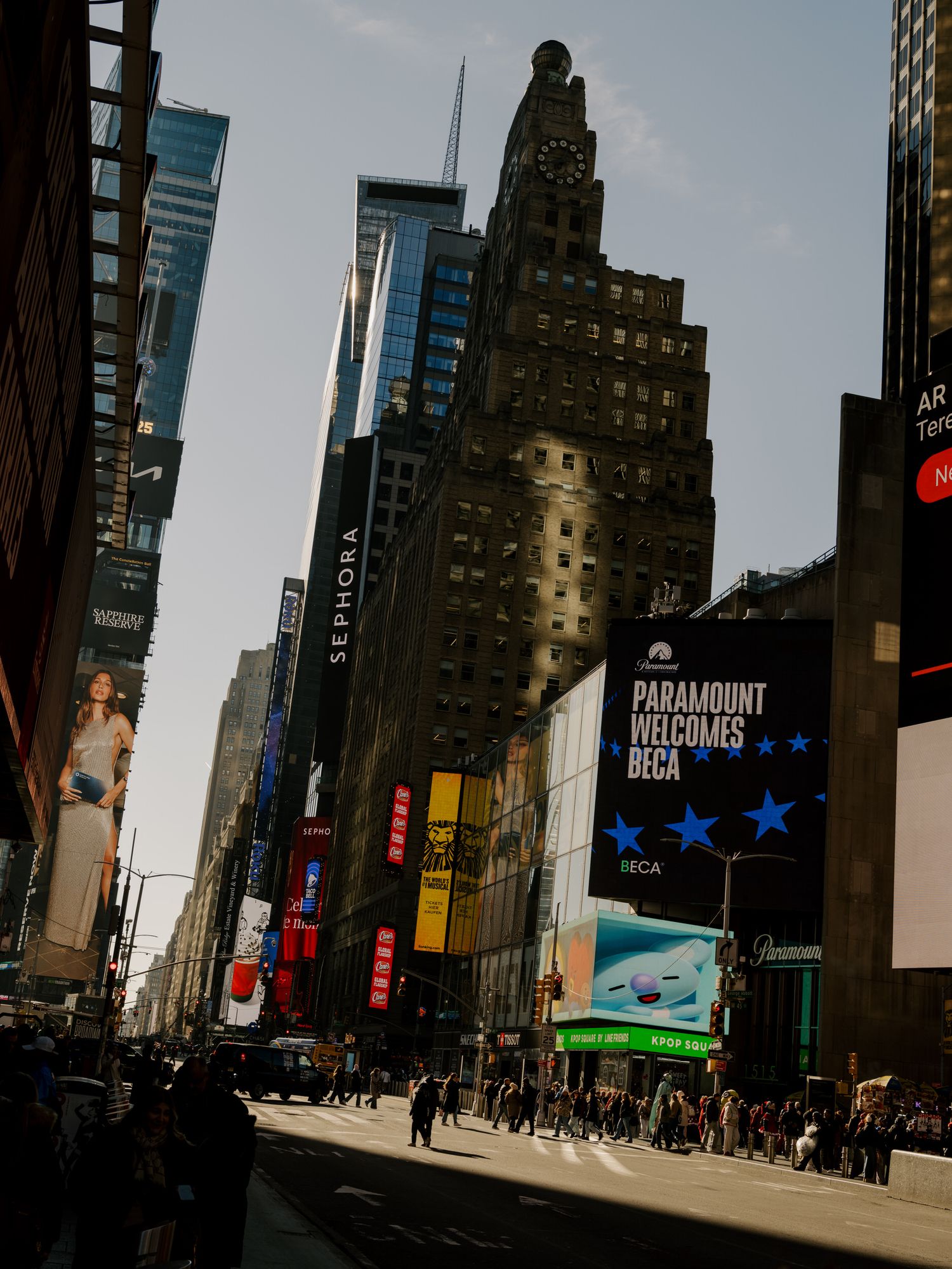 Panoramic view of Times Square in New York City with tall buildings and bright digital displays.