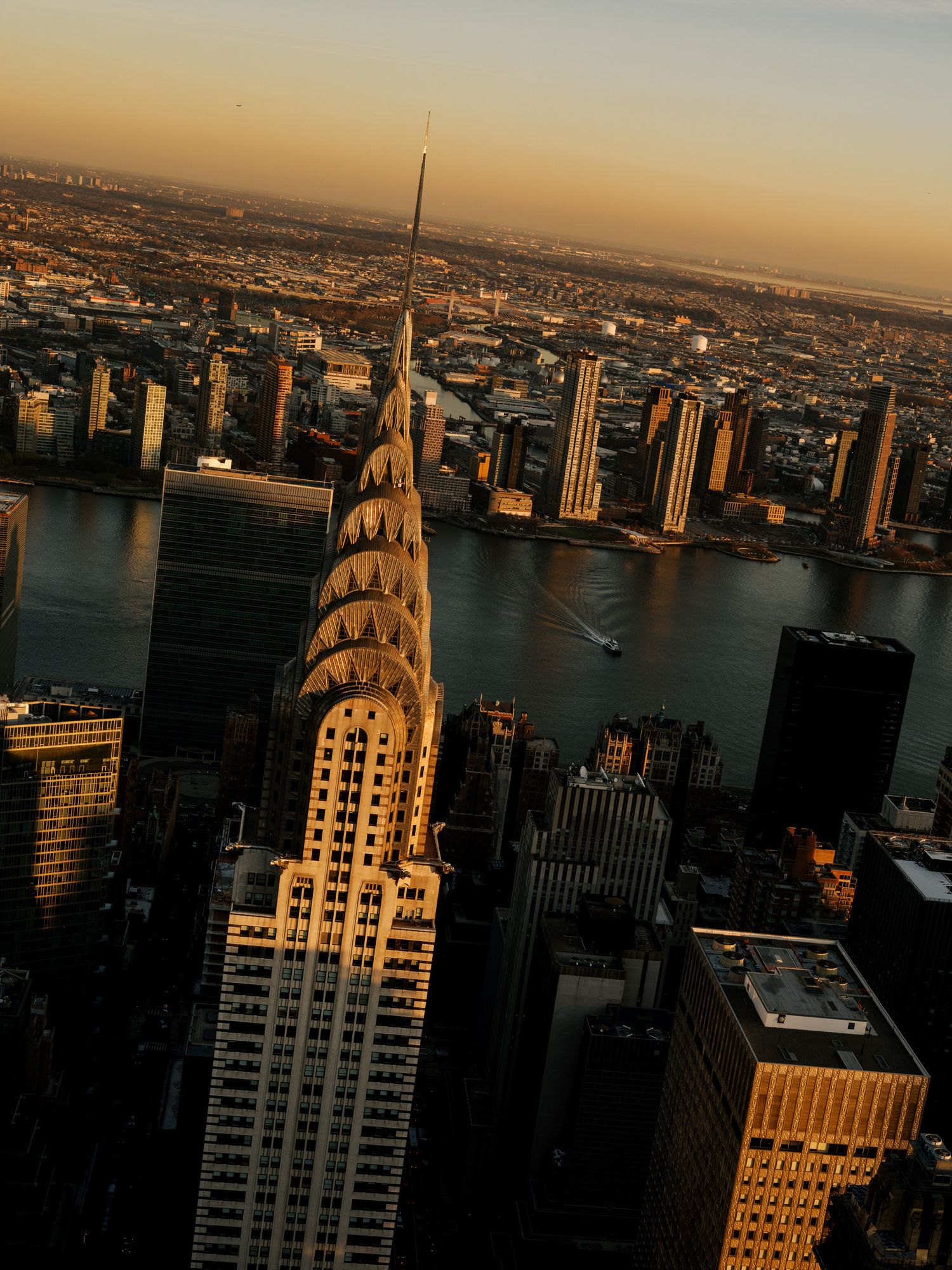 Art deco skyscraper silhouetted against golden sunset sky in New York City.