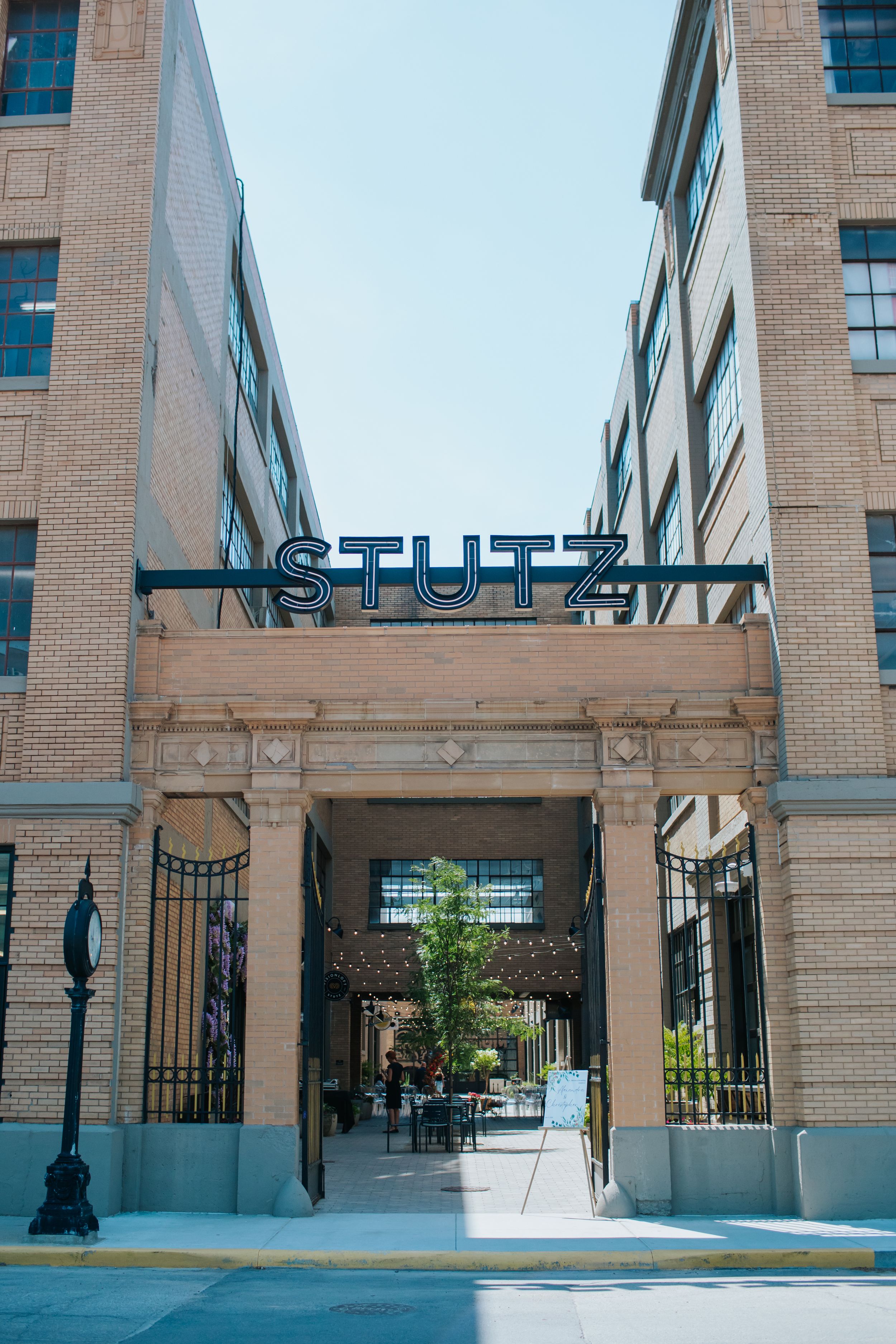 Modern brick building exterior with STLTH signage and architectural columns along a covered walkway.
