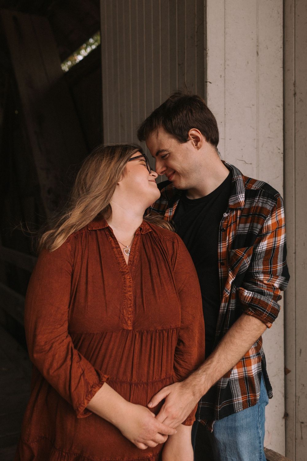 Intimate couple portraits against white wooden wall background.