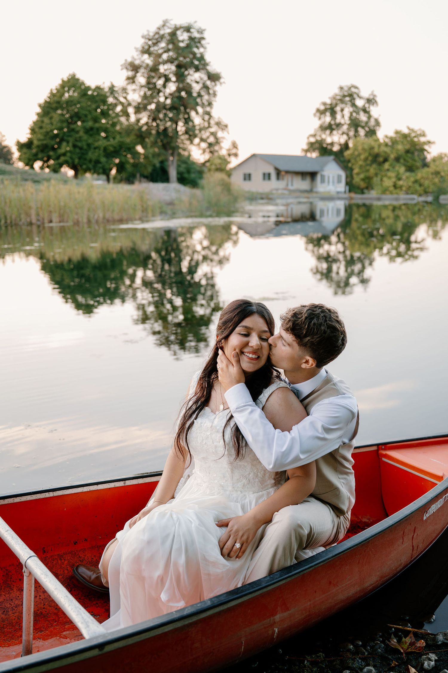 Sunset bride and groom portraits in a canoe on a pond