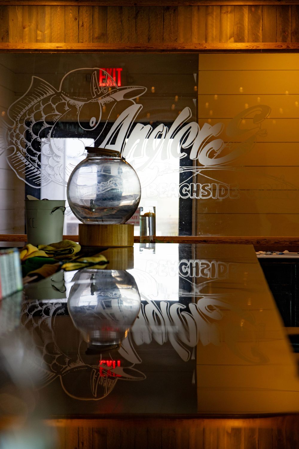 Elegant bar interior with wooden walls and decorative Coca-Cola signage illuminated in warm lighting.