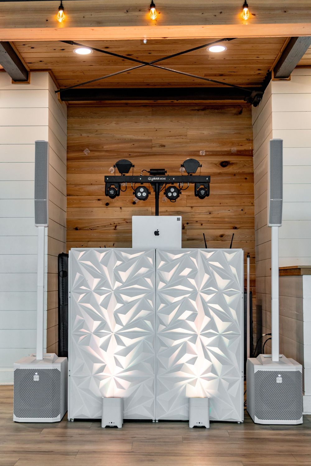 Modern white decorative wall panels with leaf patterns mounted in a wood-paneled room with pendant lighting.