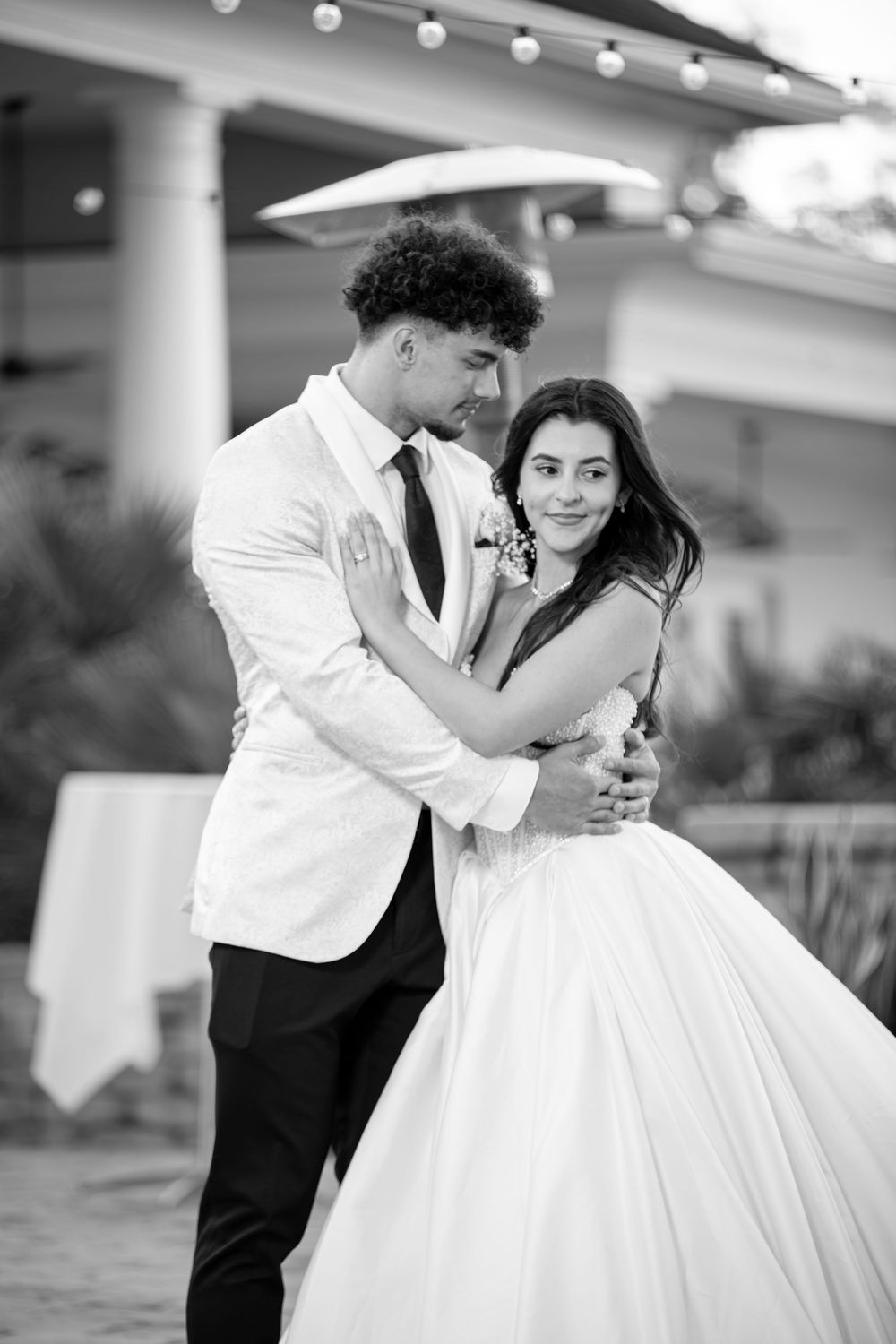 A romantic black and white wedding photo series showing a couple dancing together in formal attire.