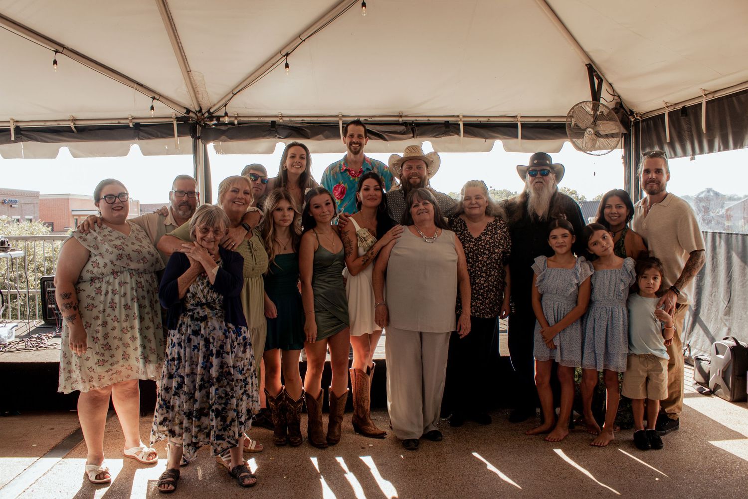 A series of group photos taken at an outdoor event under a white tent showing people gathered together.