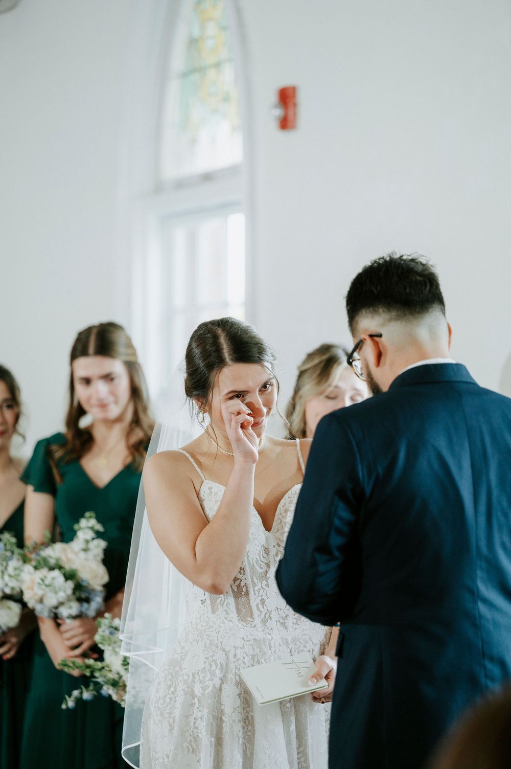 Emotional wedding ceremony sequence showing tender moments between couple and guests in a bright white venue.