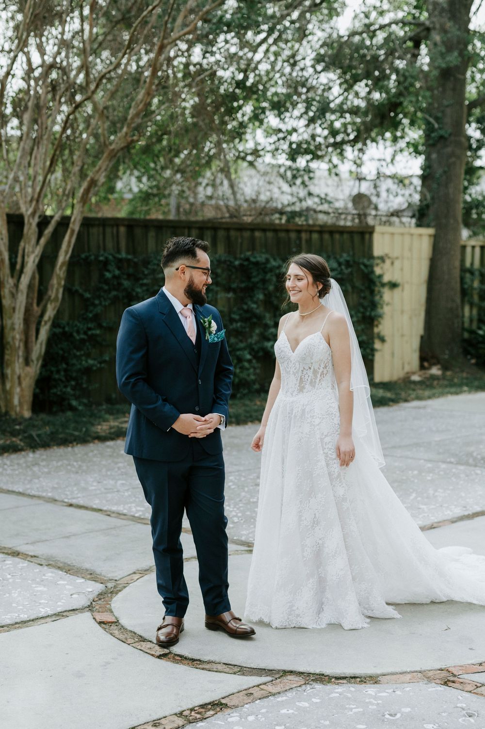 Bride and groom share a sweet first look moment on their wedding day in a garden setting.