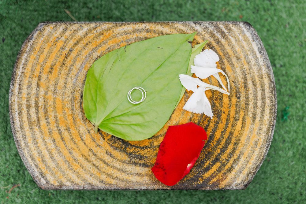 Wedding rings displayed on decorative green and gold circular platter.