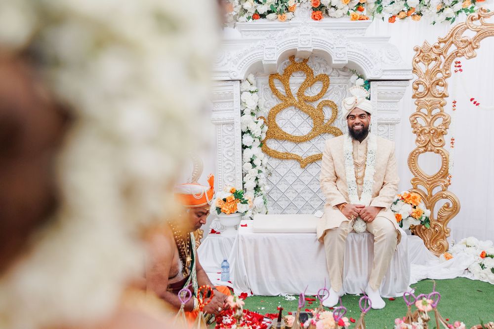 Ornate gold and white wedding decor with floral arrangements creates an elegant backdrop for a traditional ceremony.