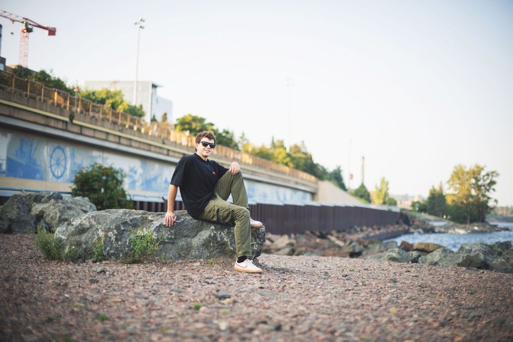 Skateboarder performs a trick sequence over concrete obstacles at a skate spot during sunset.