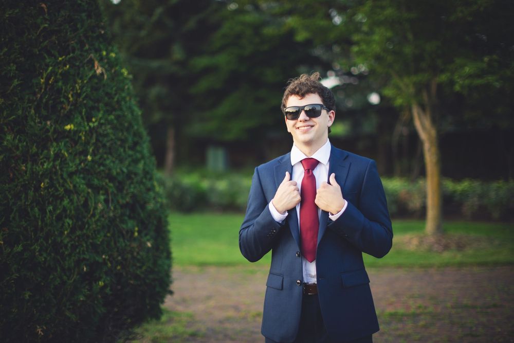 High school senior standing outdoors, smiling naturally at the camera.