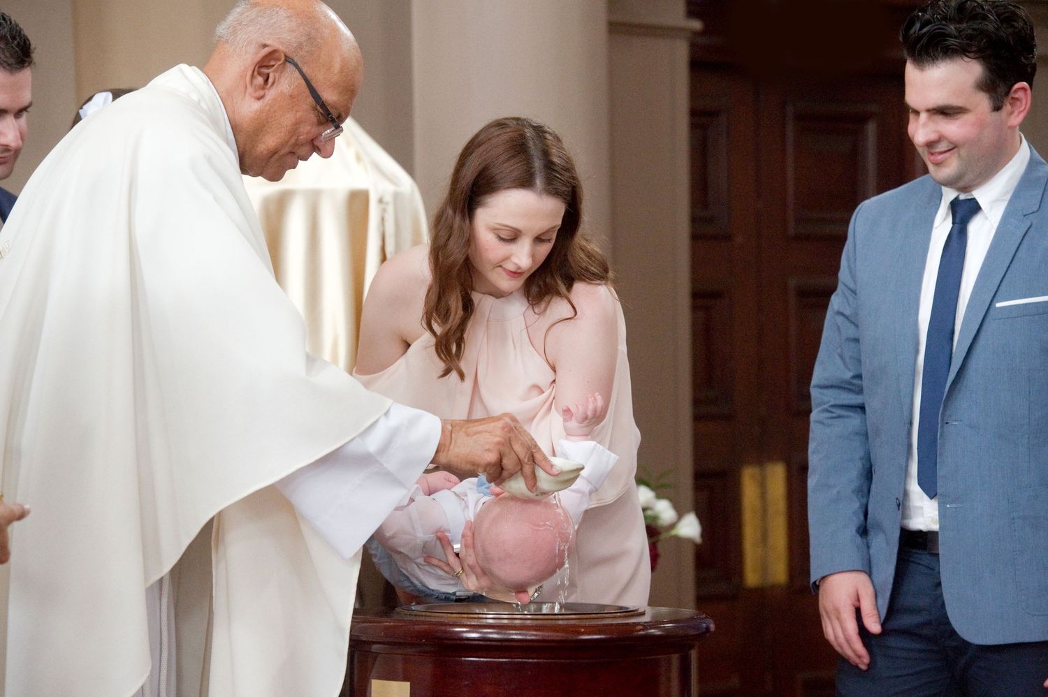 Priest performs baptismal blessing during traditional church ceremony.