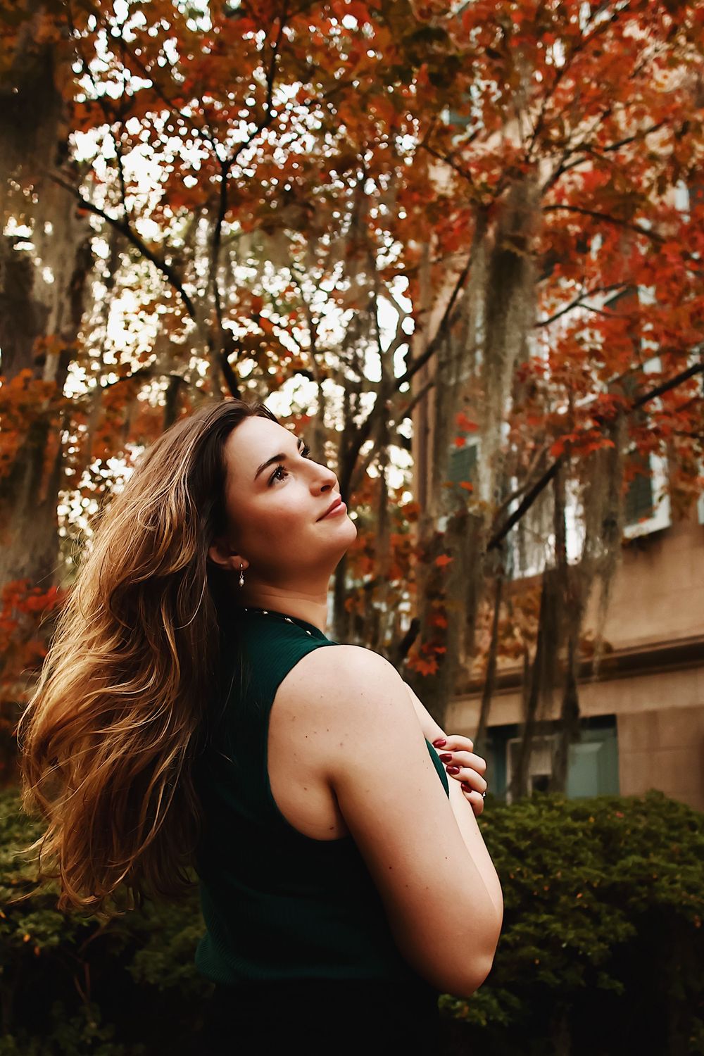 Artistic autumn portraits with warm tones showing movement against fall foliage and trees.