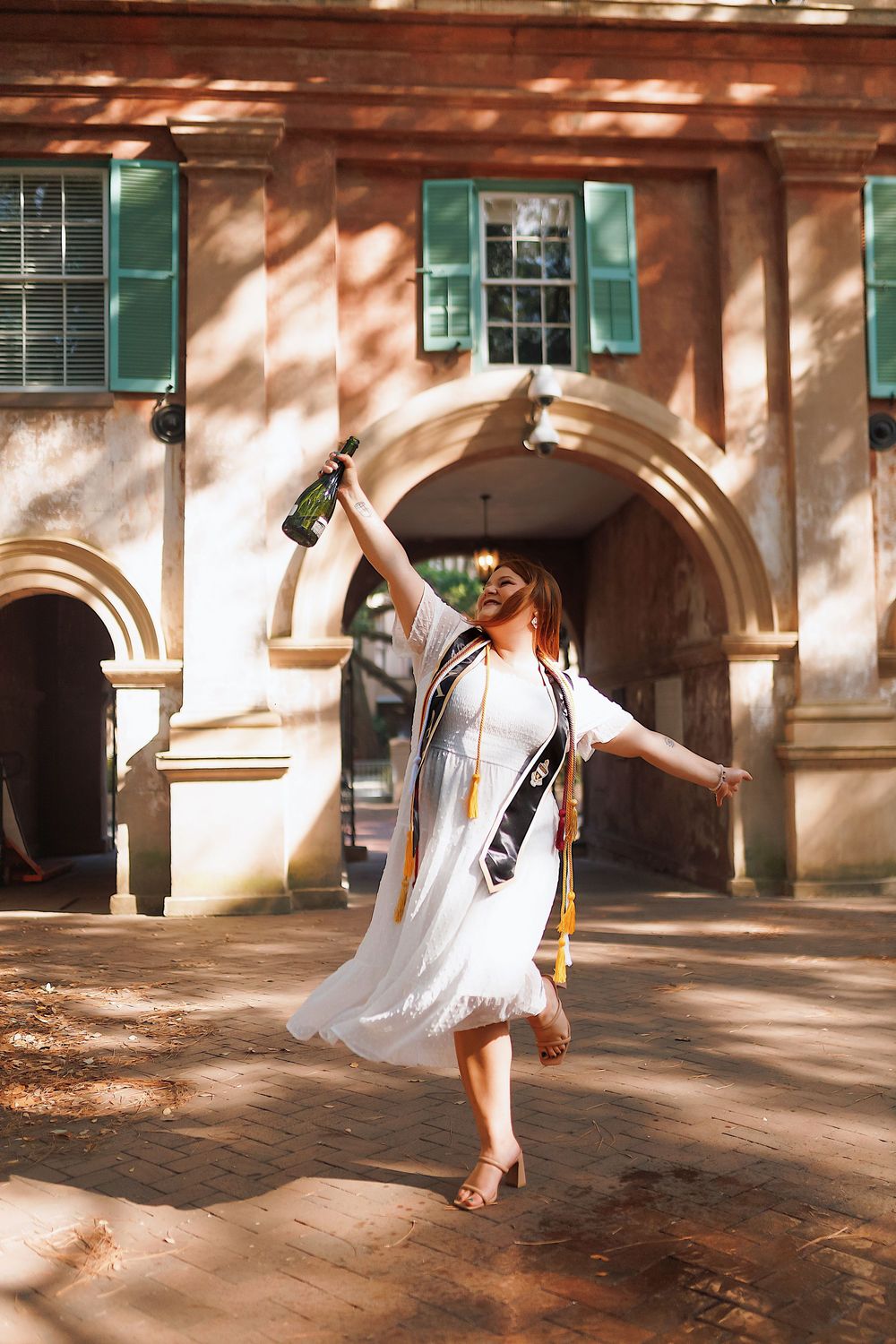 A sequence of dance movements showing a figure in white flowing dress spinning gracefully in dappled sunlight under arches.