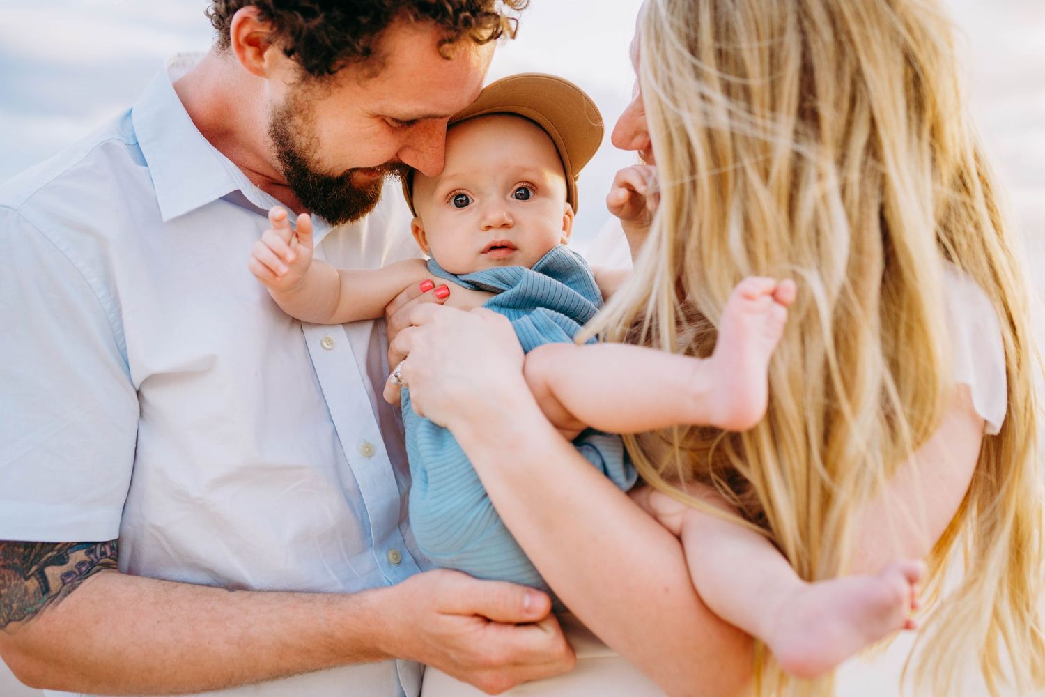 Intimate family portrait session with parents and baby in casual attire. best hawaii family photographer kihei wailea kaanapali makena