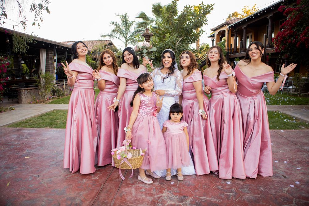 Pareja en sesión de Save the Date, holding sign with wedding date in a beautiful outdoor location bridesmaids damas de honor vestido salmon