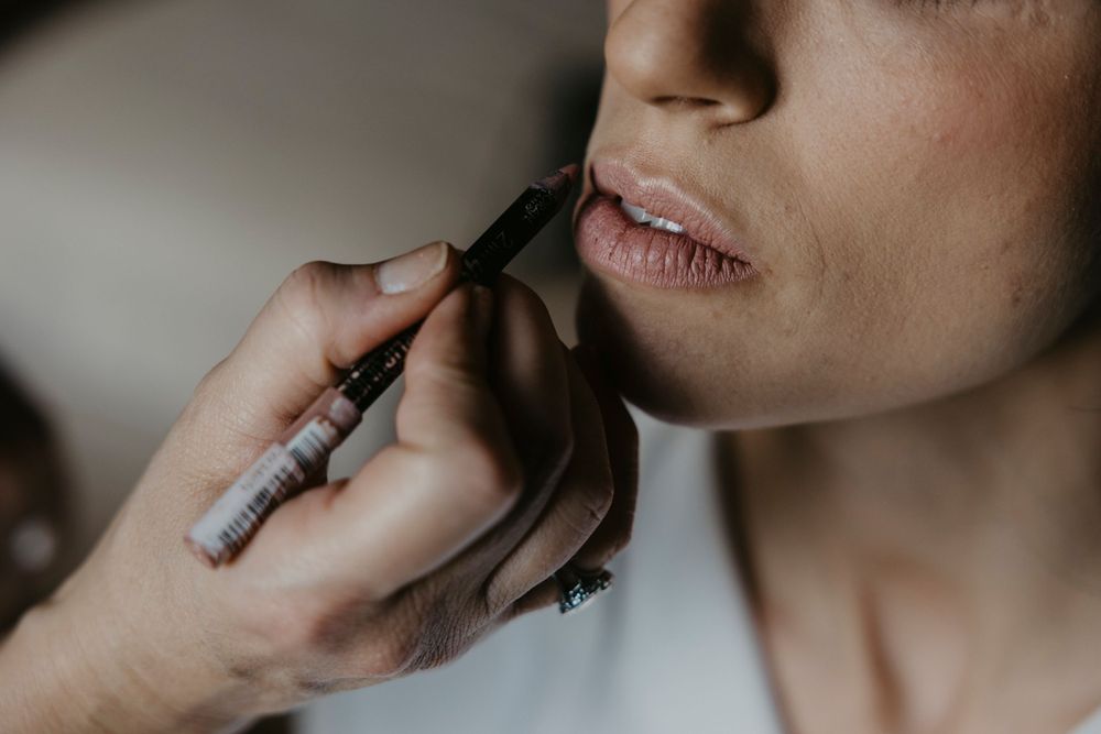 Close-up details of hands and lips during a wedding ceremony preparation.