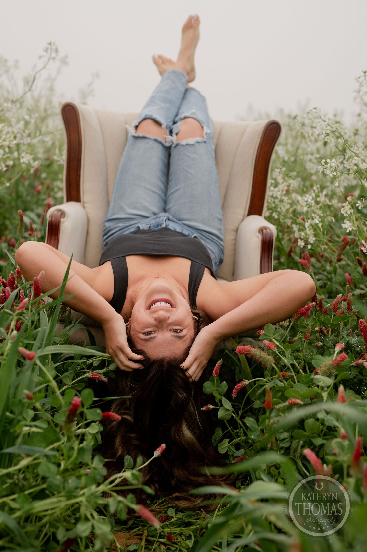 A carefree pose in a vintage armchair surrounded by wildflowers and natural greenery.